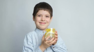 Elinde bir bardak limon suyu tutan mutlu altı yaşındaki çocuk.