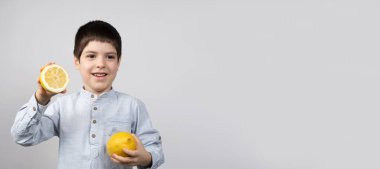 Açık Gri Arkaplanda Limonlu Küçük Çocuk. Metin için Boşluğu olan Pankart.