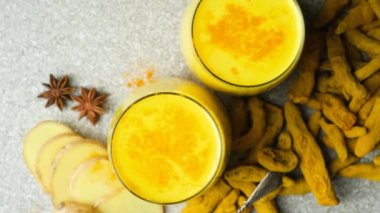 Altın süt, siyah gri arka planda iki kadehte zerdeçal içeren geleneksel bir Ayurvedik içeceği..