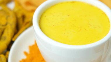 Geleneksel Ayurvedic zerdeçal, siyah biber ve zencefilli altın süt içer