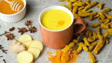 Zemin zerdeçal altın süte dökülüyor, geleneksel bir Ayurvedik içeceği yapıyor, yavaş çekim.
