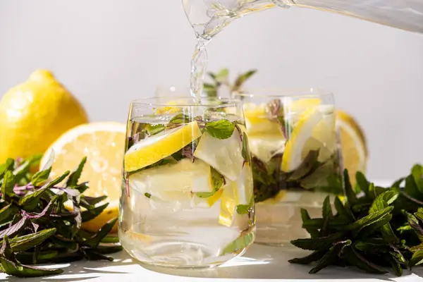 stock image Lemon water with mint pouring into glass