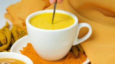 Altın süt ve zerdeçal, içkiyi kaşıkla karıştırmak, ağır çekim.