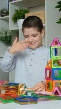 Çocuk, eliyle başını tutarak manyetik yapı setine şaşırmış görünüyor.