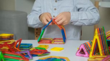 Manyetik yapıcıyla oynayan çocuk, eller yakın plan