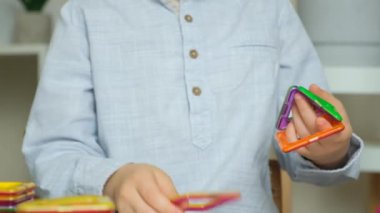Manyetik yapıcıyla oynayan çocuk, eller yakın plan