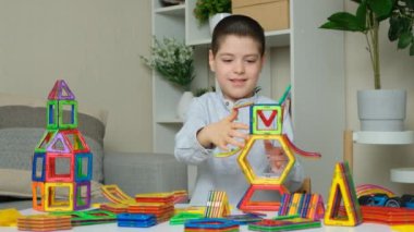 Altı yaşında bir çocuk manyetik bir inşaat setiyle oynuyor. Çocukların hayal gücünü geliştirmesi için oyuncaklar.