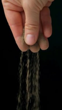 Siyah arka planda ağır çekim üzerine siyah karabiber dökülüyor