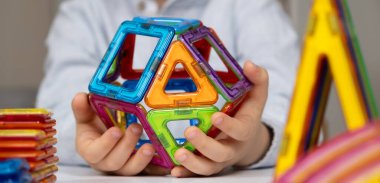 Manyetik yapıcıyla oynayan çocuk, eller yakın plan