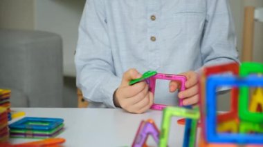 Manyetik yapıcıyla oynayan çocuk, eller yakın plan