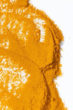 Beyaz arkaplanda bir zerdeçal lekesi, üst görünüm.