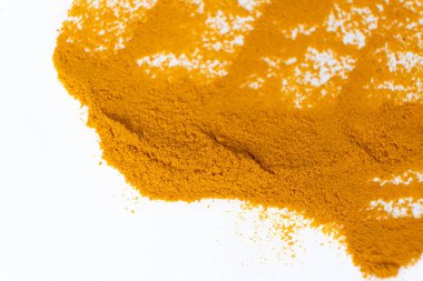 Beyaz arkaplanda bir zerdeçal lekesi, üst görünüm.