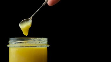 Doğal ghee sağlıklı yağ, siyah arkaplan.