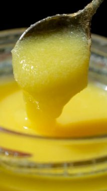 Taze kahve yağı kaşıktan kavanoza akıyor, yavaş çekim dikey çekim.