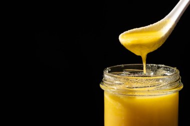 Kızartma, siyah arkaplan, metin için kopyalama alanı için doğal ghee sağlıklı laktozsuz yağ.