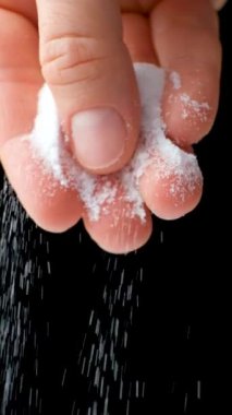 Siyah zemine el tuzu dökerek, dikey ağır çekim