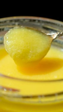 Taze kahve yağı kaşıktan kavanoza akıyor, yavaş çekim dikey çekim.