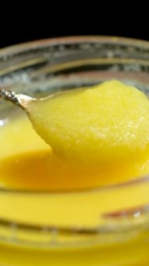 Taze kahve yağı kaşıktan kavanoza akıyor, yavaş çekim dikey çekim.