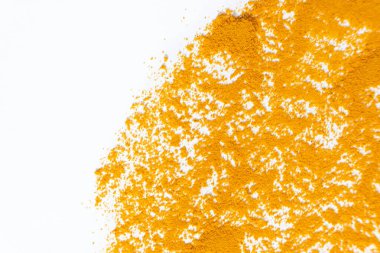 Beyaz arkaplan görünümüne dökülen zerdeçal tozunun soyut turuncu arkaplanı.