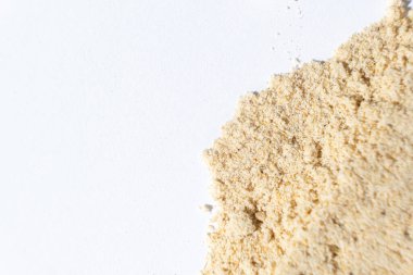 Macro zencefil tozu döktü. Beyaz arka planda zencefil kökü.