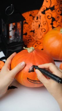 Hokkaido balkabağına göz, burun ve ağız çizer. Cadılar Bayramı için Jacks Feneri Oluşturuluyor