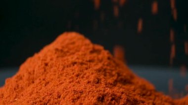 Baharatlı tütsülenmiş kırmızı biber siyah arka plana makro döker