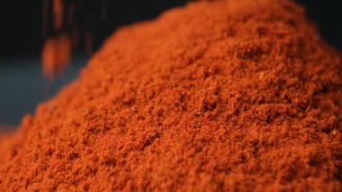 Baharatlı tütsülenmiş kırmızı biber siyah arka plana makro döker