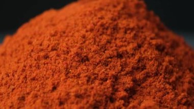 Baharatlı tütsülenmiş kırmızı biber siyah arka plana makro döker