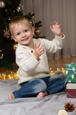 İki yaşındaki küçük çocuk Noel hediyelerini evde açıyor..