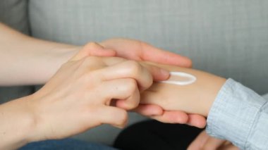 Annem bir çocuğun eline kozmetik kremi sürüyor. Çocuklar için cilt bakımı ve korunma.