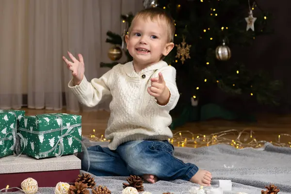 İki yaşındaki küçük çocuk Noel hediyelerini evde açıyor..