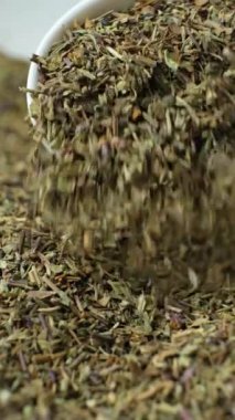 Baharatlı fesleğen kaşıktan yavaş çekimde dikey olarak dökülür.