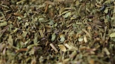 Makro yavaş çekim, kurutulmuş fesleğen çeşnisi dökülüyor.