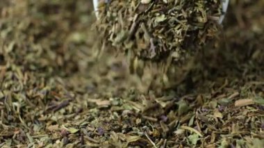 Baharatlı fesleğen kaşıktan yavaş çekim makrosu dökülür.