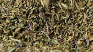 Makro yavaş çekim, kurutulmuş fesleğen çeşnisi dökülüyor.