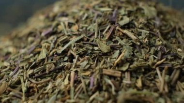 Makro yavaş çekim, kurutulmuş fesleğen çeşnisi dökülüyor.