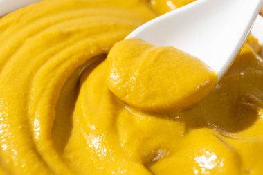 Geleneksel baharatlı hardal sosu yakın plan kaşıkta.