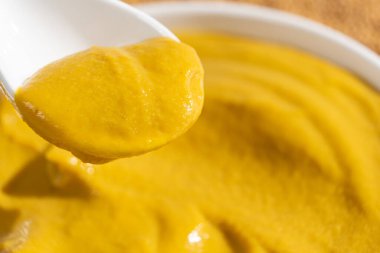 Geleneksel baharatlı hardal sosu yakın plan kaşıkta.