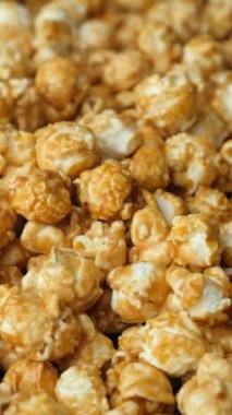 Karamelleştirilmiş patlamış mısırın yavaş dönüşü, dikey video.