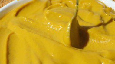 Yavaş çekimde kaşıkla hardal sosu karıştırmak.