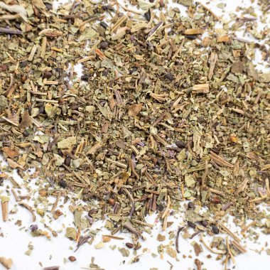 Beyaz arkaplanda kuru fesleğen baharatlı makro doku