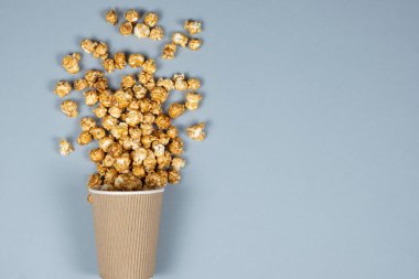 Sweet caramelized popcorn spilled out of the glass. Copy space for text clipart