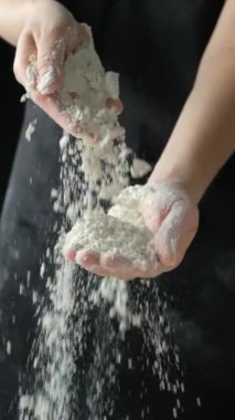 Aşçı buğday ununu elden ele düşey ağır çekimde döker.