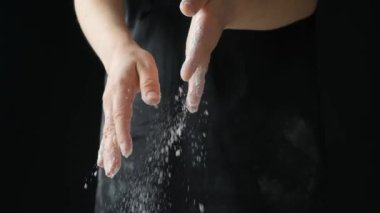 Aşçı el sıkışarak buğday unu, siyah arka plan, yavaş çekim