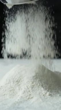 Buğday unu, dikey ağır çekimde metal elek ile eleme işlemi.