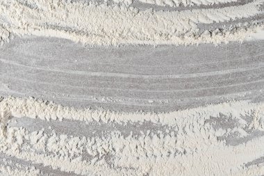 Arkaplanda dökülen buğday ununun gri pişirme arka planı, üst görünüm