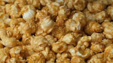 Karamelli patlamış mısır dökülüyor ve dönüyor, ağır çekimde..