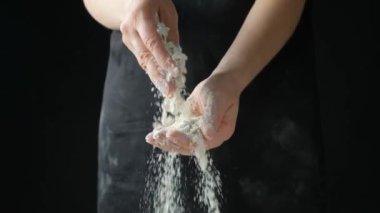 Aşçı buğday ununu elden ele ağır çekimde döker.