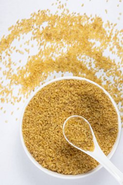 Pişmemiş bulgur, kaşık ve tabak üst görüşünde buğdayı çatlattı..