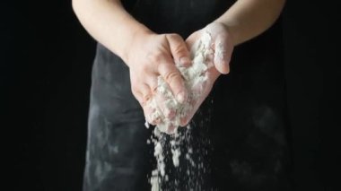 Aşçı buğday ununu elinden döküyor, ağır çekimde.